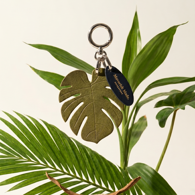 Keychain with leaf design on a plant with a neutral background